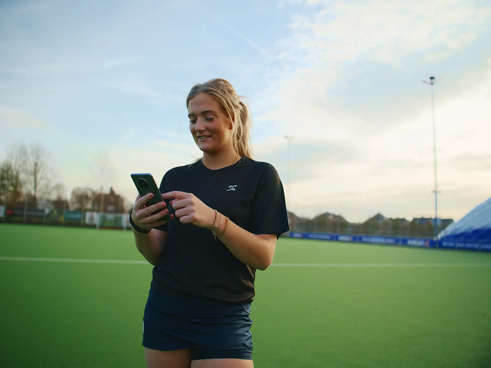 Hockeyspeler bekijkt haar voortgang in de X-Skills-app op het veld