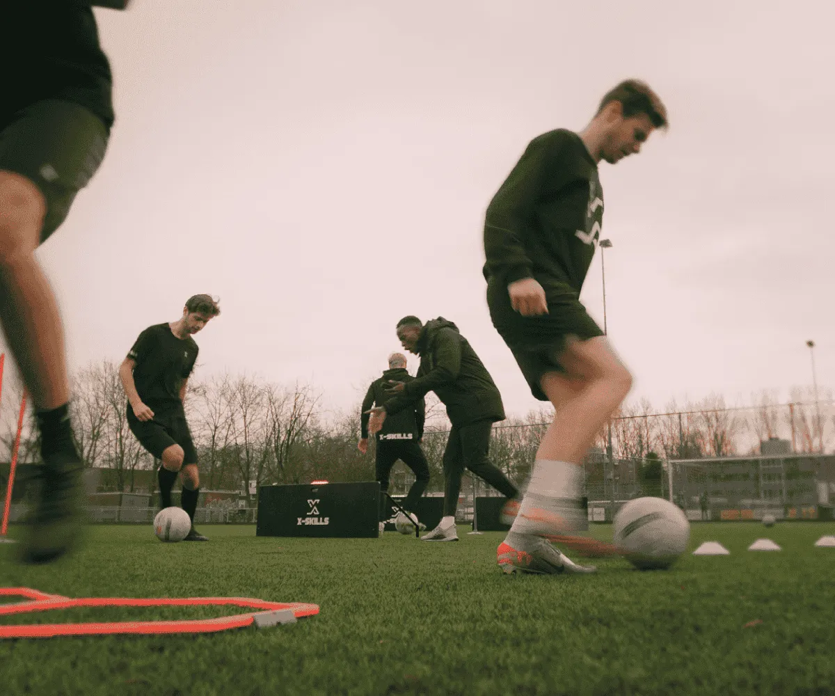 Trainer begeleidt een voetbalteam tijdens een X-Skills training